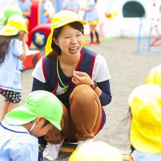 広い園庭でこども達がのびのびと遊んでいる幼稚園